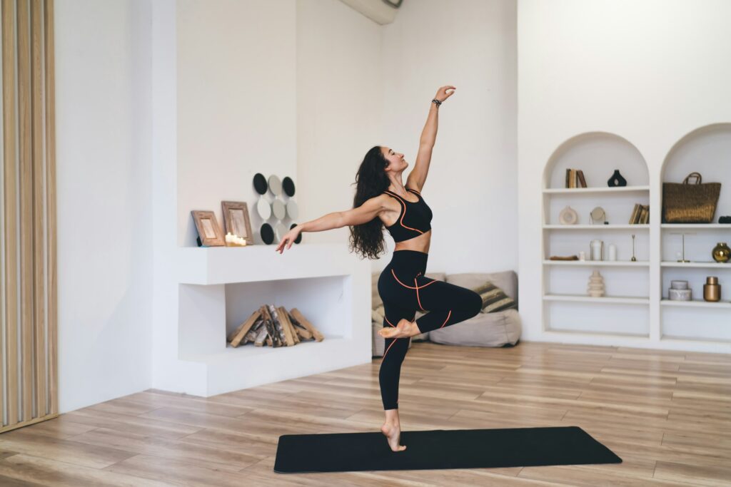 Slim woman standing in dance pose in living room